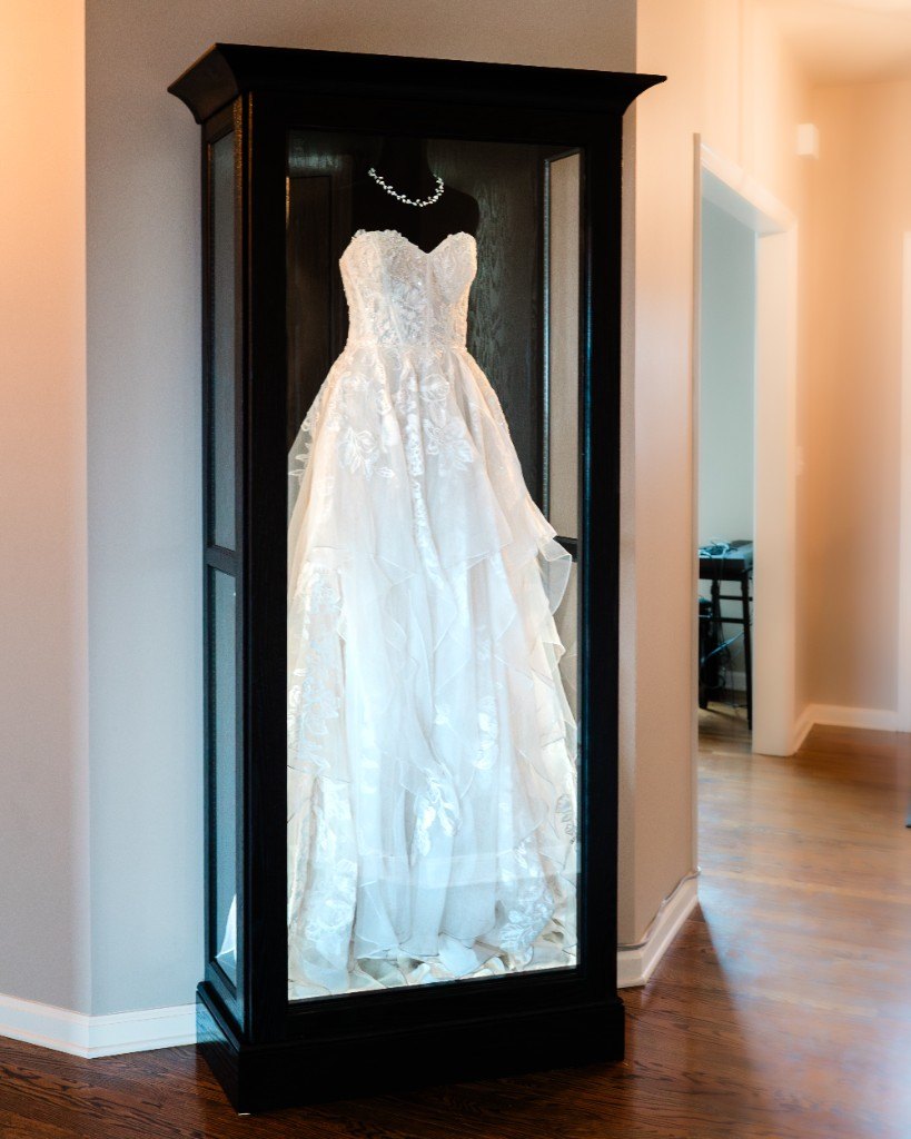 A freestanding Mrs. Case Signature displaying a ballgown in a hallway