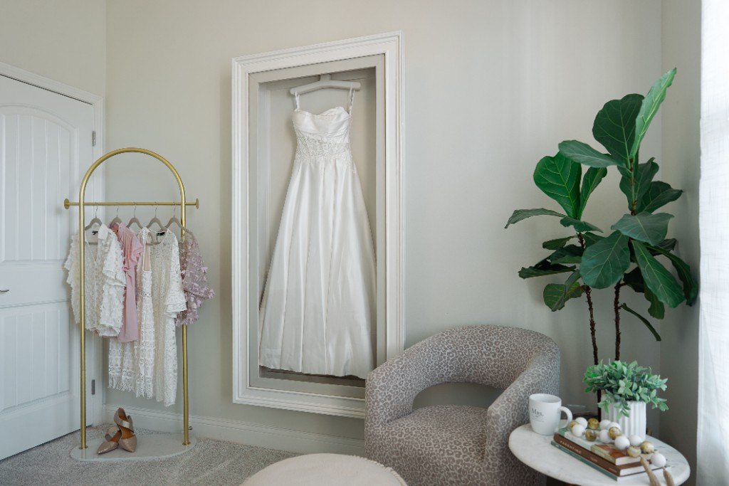 A wall-mounted Mrs. Case Gallery displaying a satin gown in a dressing room