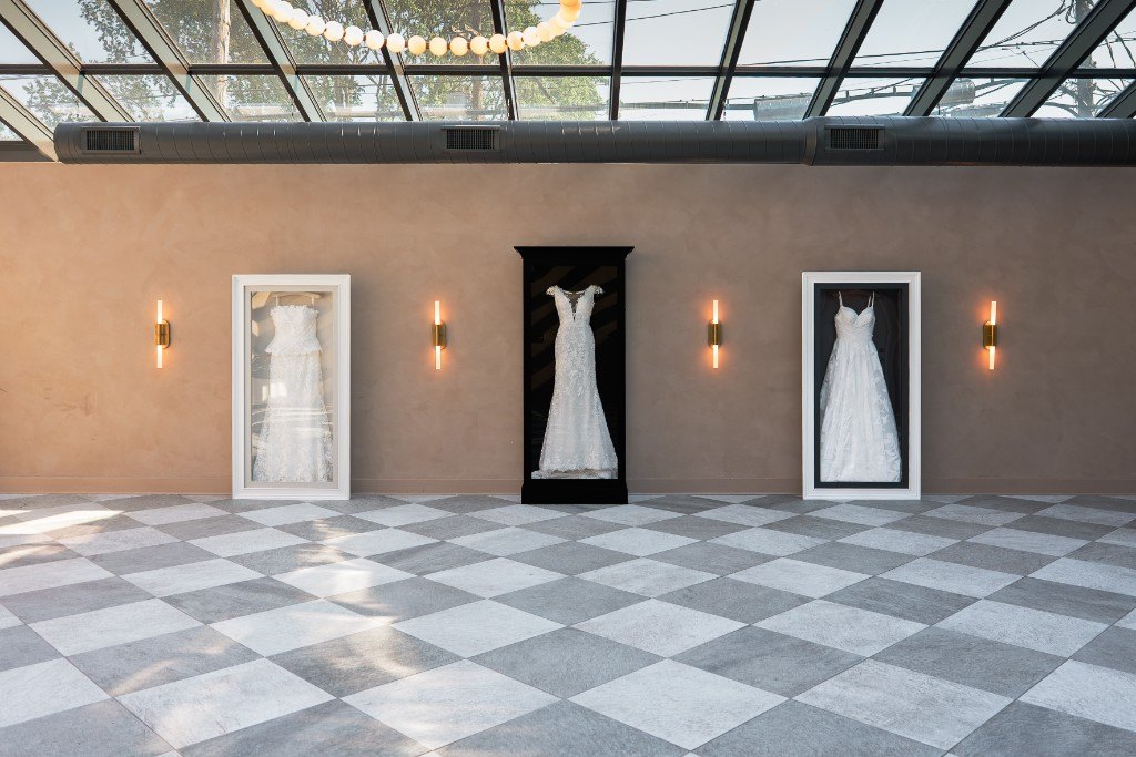 Two wall-mounted Gallery cases flanking a freestanding Signature case in a showroom