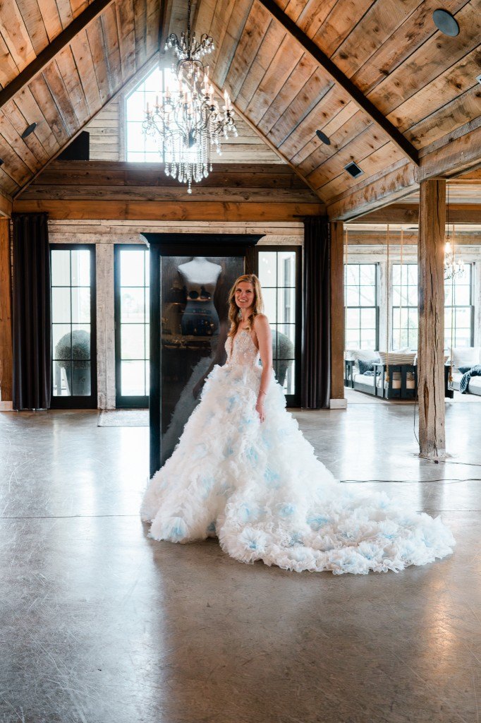 A bride standing in front of a freestanding Mrs. Case in a timber hall